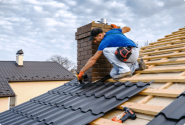A man working at heights and roofing a house