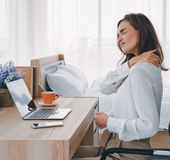 a woman with neck pain from her poor office ergonomics