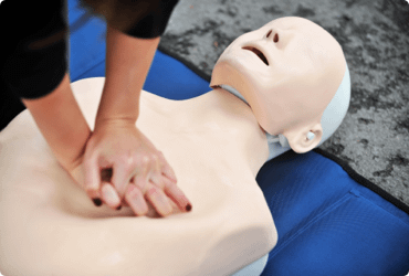 An employee practices CPR on a dummy