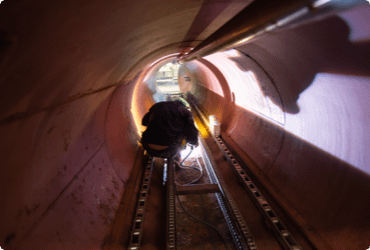 A worker moves through a confined space after completing their confined space awareness training