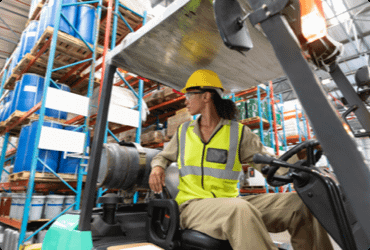 An employee reverses a forklift after taking the forklift refresher course