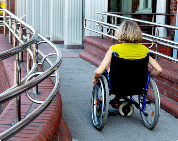 A worker in a wheelchair moves down a path
