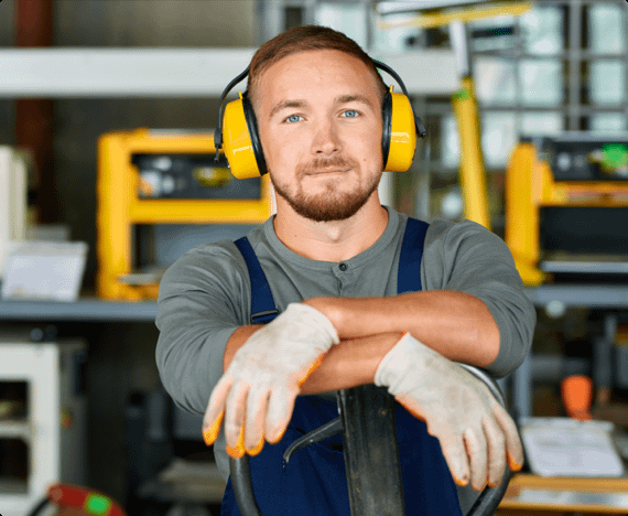 An employee wears hearing protection equipment in a workshop